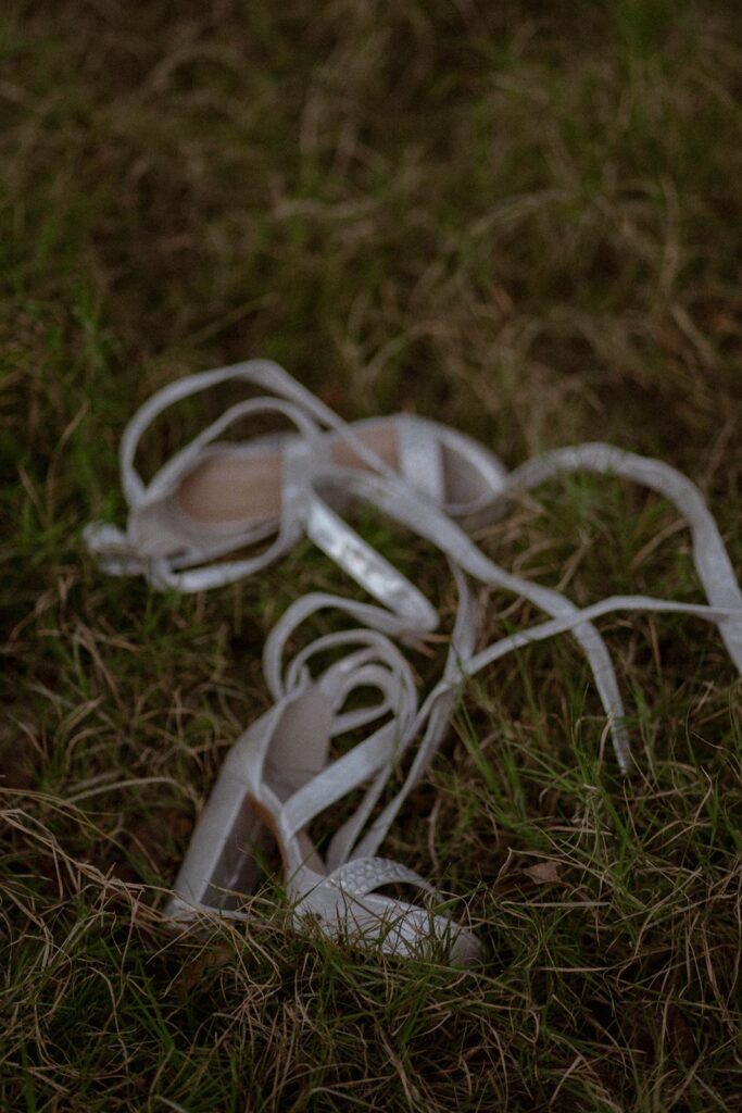 bride's shoes on the ground in the hill country.